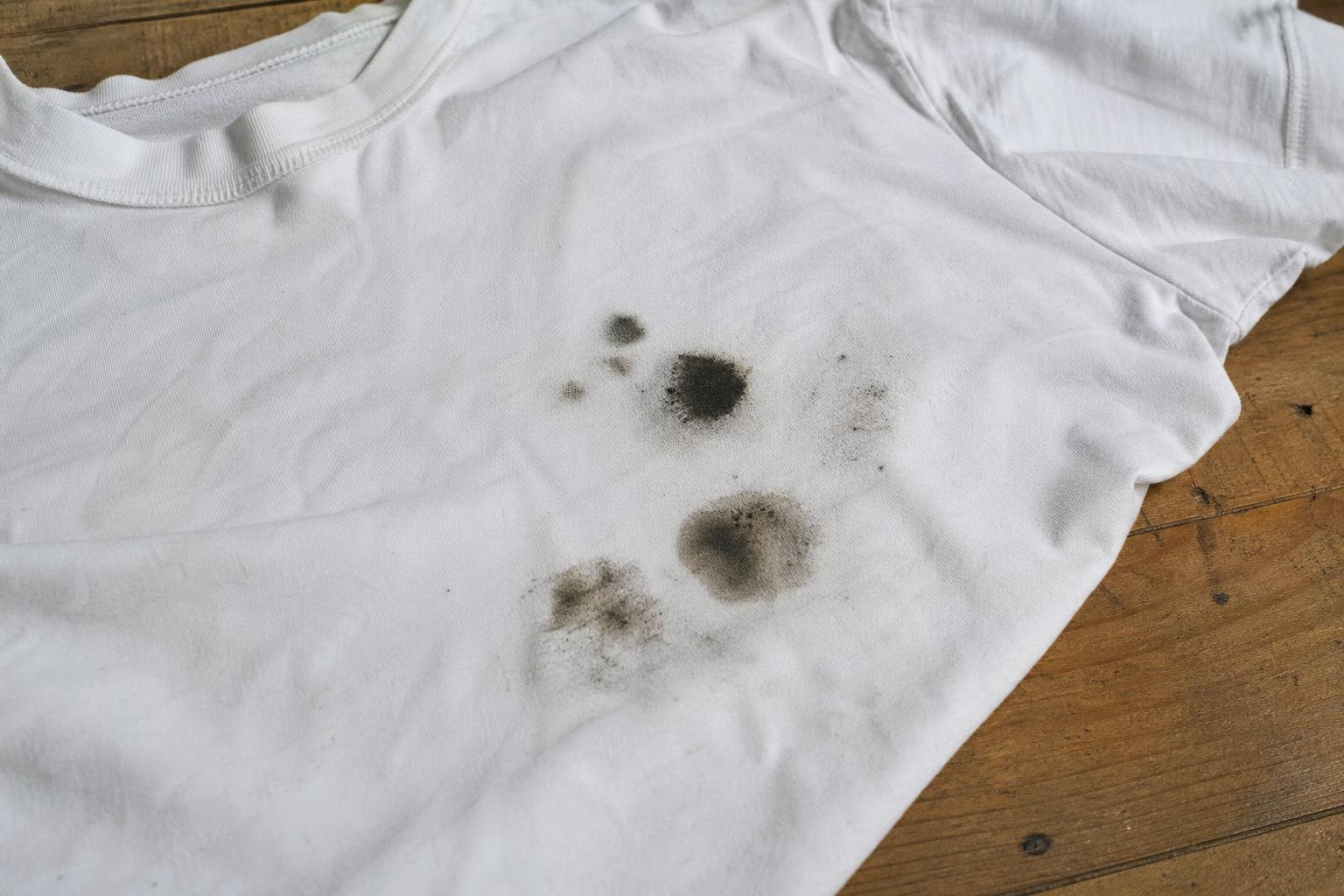 Manchas escuras de óleo em roupa branca após a lavagem, causadas por vazamento do mecanismo