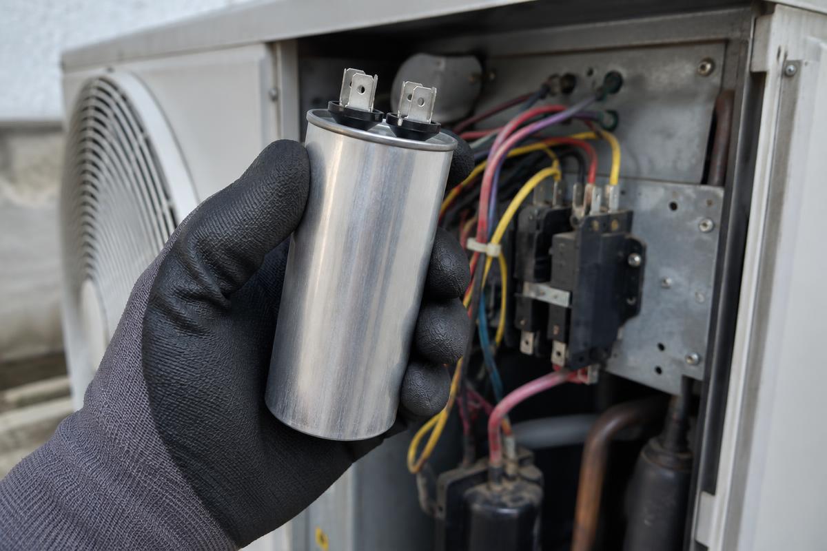 Capacitor cilíndrico de partida retirado da caixa elétrica de uma unidade condensadora