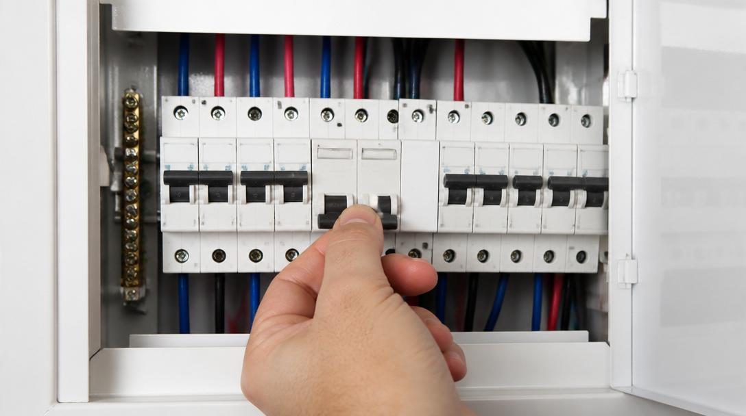 Disjuntor do circuito 220V do cooktop de indução sendo verificado no quadro