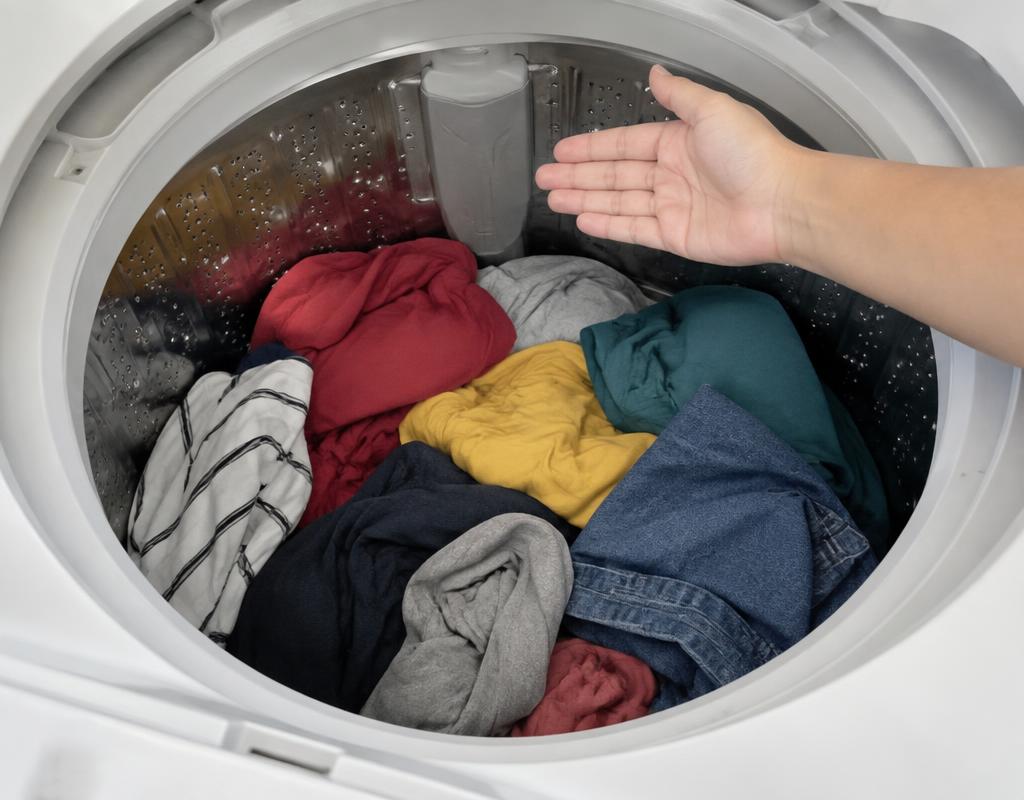 Tambor de lavadora visto de cima com roupas até três quartos da capacidade