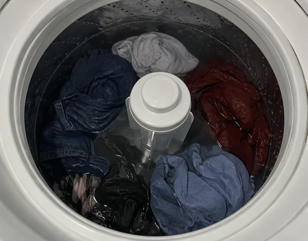 Tambor de lavadora parado com roupas encharcadas dentro