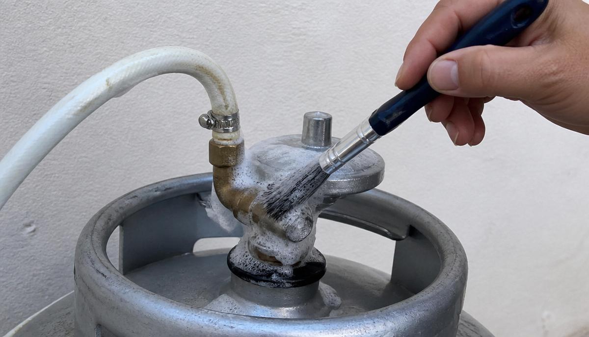 Aplicação de espuma de sabão nas conexões após a troca da mangueira de gás