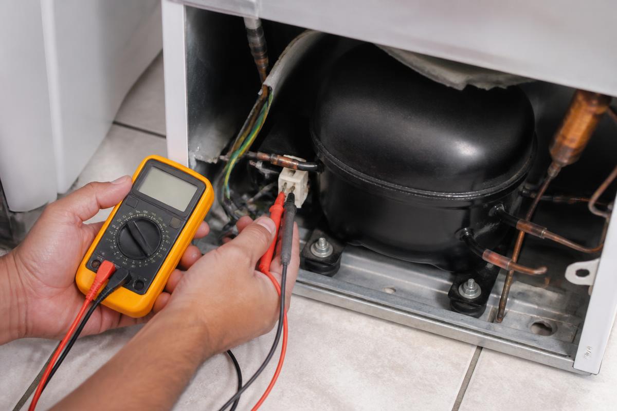 Medição de resistência ôhmica nos terminais do compressor na traseira da geladeira