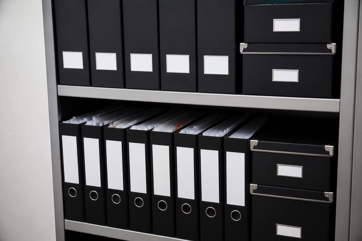 Pastas e arquivos de documentos organizados em prateleira de escritório