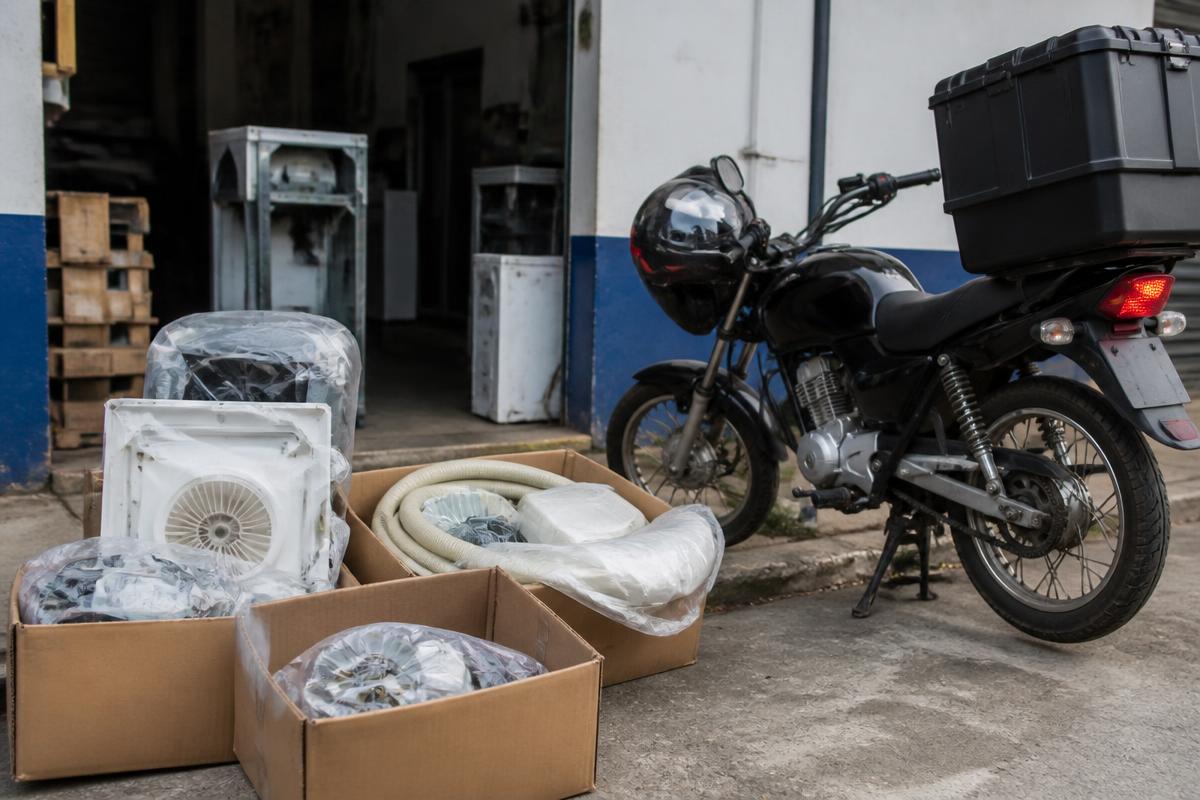 Caixas de peças de reposição ao lado da moto de serviço em frente à oficina