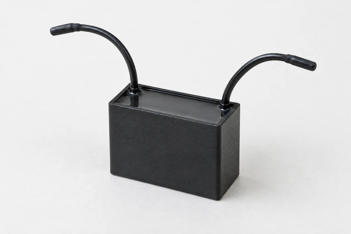Capacitor de motor genérico inteiro e desconectado, com dois fios de pontas isoladas.